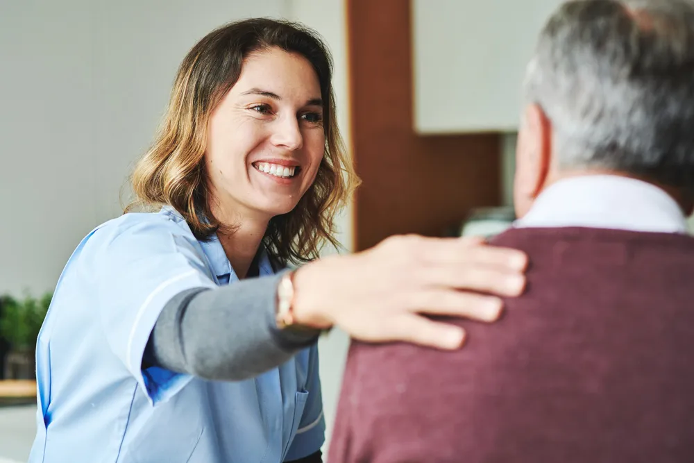 Zorgverlener en oudere patiënt in gesprek in de ouderzorg